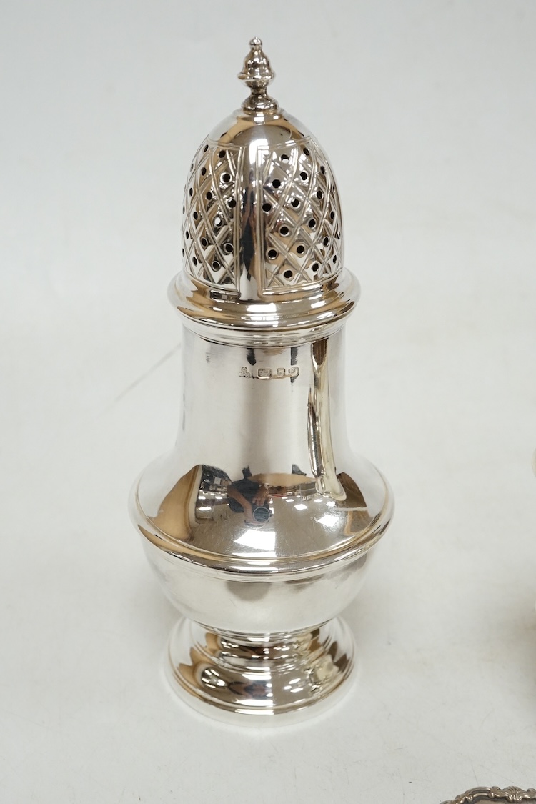 A 1970's silver sugar castor by SCR Ltd, London, 1973, 14.7cm, together with a small silver milk jug and a pair of late Victorian small silver dishes, Miller Brothers, Birmingham, 1899.